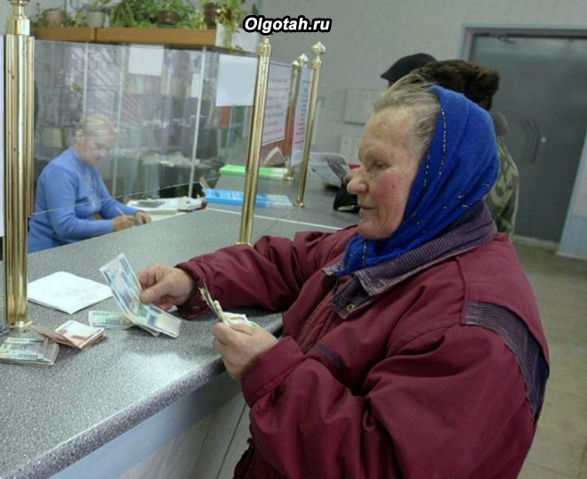 Пенсионерка покупает билет в кассе